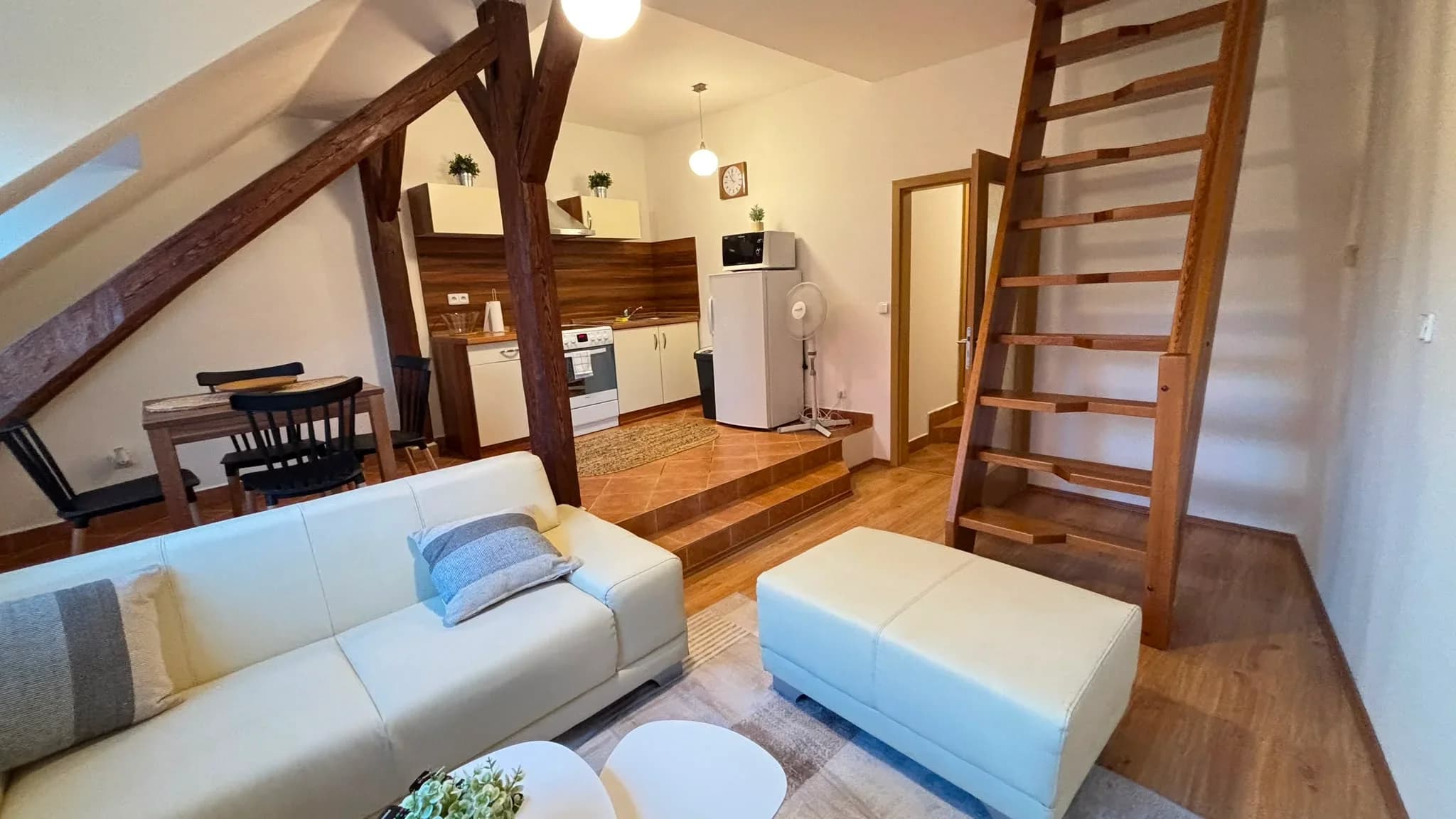 Apartmán 3, obývací pokoj se sedačkou a schody do podkroví